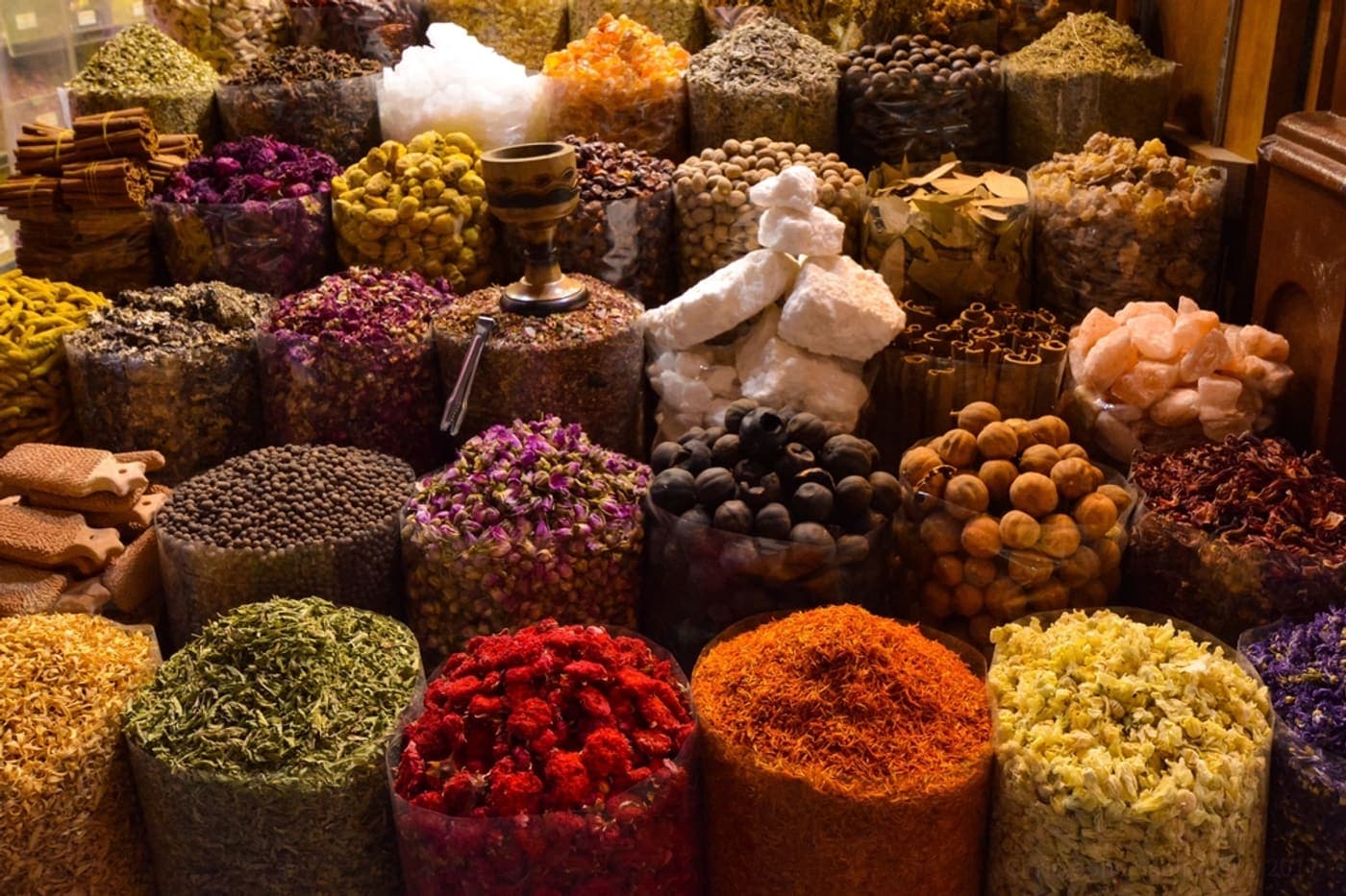 Open sacks of spices and dried goods on a market stall.