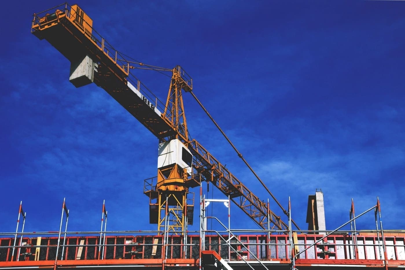 A tower crane above the frame of a building under construction.